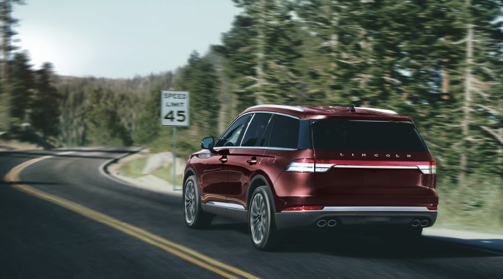 A 2024 Lincoln Aviator® SUV is being driven on a winding mountain road | Johnson Sewell Lincoln in Marble Falls TX
