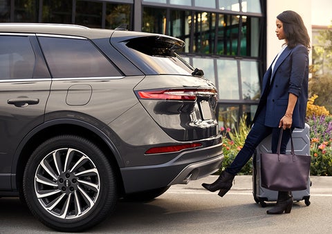 A woman with her hands full uses her foot to activate the available hands-free liftgate. | Johnson Sewell Lincoln in Marble Falls TX