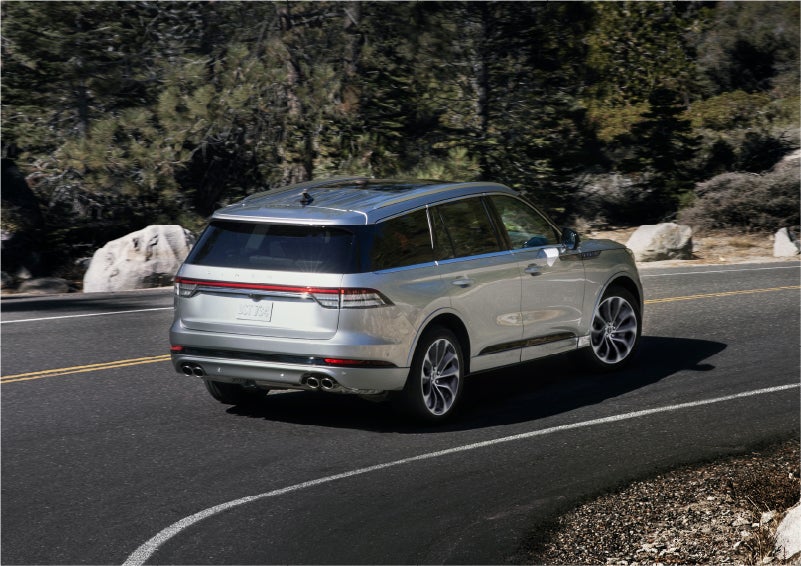 A 2023 Lincoln Aviator® Grand Touring model is shown being driven on a tight turn of a mountain road | Johnson Sewell Lincoln in Marble Falls TX