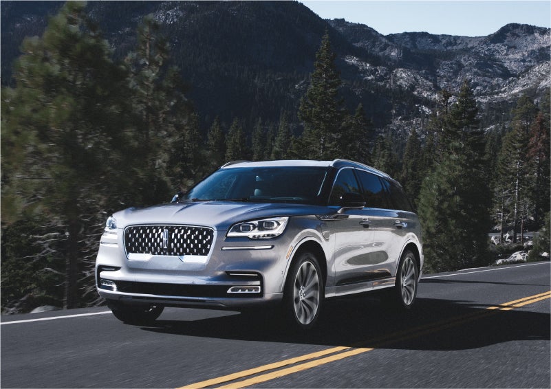 A 2023 Lincoln Aviator® Grand Touring SUV being driven on a winding road to demonstrate the capabilities of all-wheel drive | Johnson Sewell Lincoln in Marble Falls TX